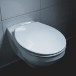 A sleek and modern white toilet in a well-lit minimalist bathroom setting.